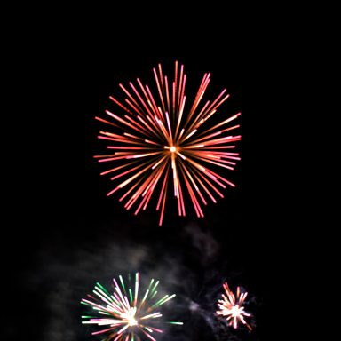 Colourful fireworks exploding in a dark night sky.