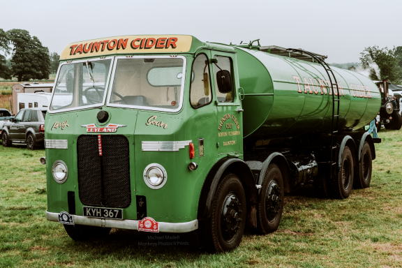 A vintage green tanker truck with "Somerset Cider" on the cab.